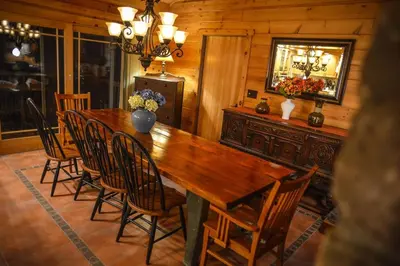 a dining room with a wooden table and chairs at Colgate Lake Lodge in East Jewett