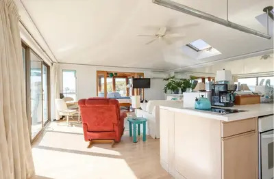 a kitchen with a red chair and a living room at Hudson Riverfront Home in Catskill