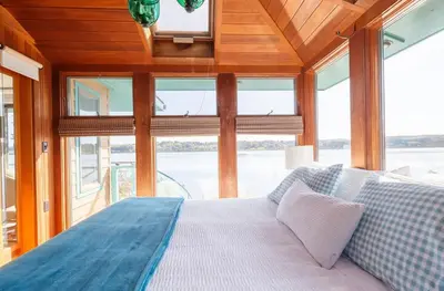 a bedroom with a bed in a room with windows at Hudson Riverfront Home in Catskill