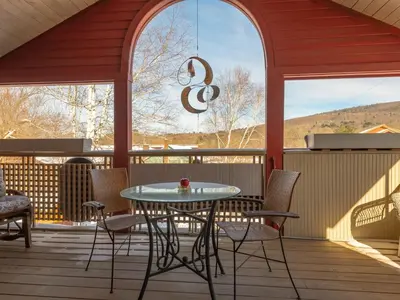 a patio with a table and chairs on a porch at Shaker Mill Inn in West Stockbridge