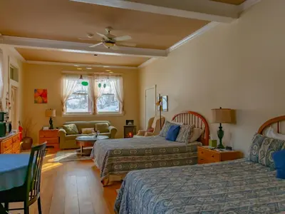 a bedroom with two beds and a living room at Shaker Mill Inn in West Stockbridge