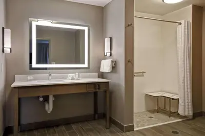 a bathroom with a sink and a mirror and a shower at Homewood Suites By Hilton Orange New Haven in Orange