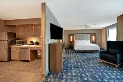 a hotel room with a bed and a kitchen at Homewood Suites By Hilton Orange New Haven in Orange