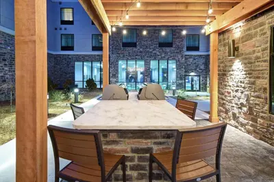 an outdoor patio with a table and chairs at Homewood Suites By Hilton Orange New Haven in Orange