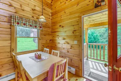 a dining room with a table and chairs and a window at Log Cabin Escape in Jacksonville