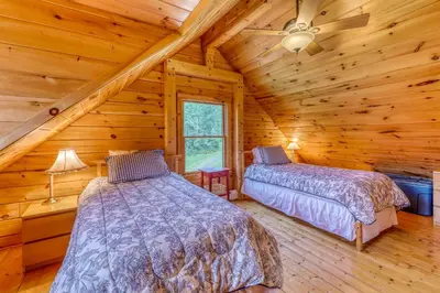 a bedroom with two beds in a log cabin at Log Cabin Escape in Jacksonville