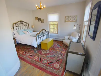 a bedroom with a bed and a chair and a rug at Mill Pond Inn in Jefferson