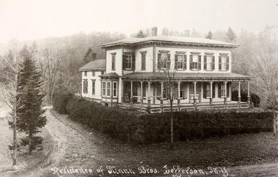 an old photo of a large house on a hill at Mill Pond Inn in Jefferson
