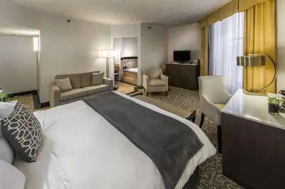 a hotel room with a large bed and a living room at Radisson Lackawanna Station Hotel Scranton in Scranton