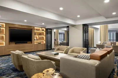 a living room with a couch and a tv at New York Hilton Midtown in New York