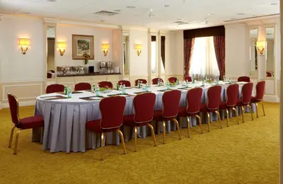 a conference room with a long table and red chairs at Warwick New York in New York