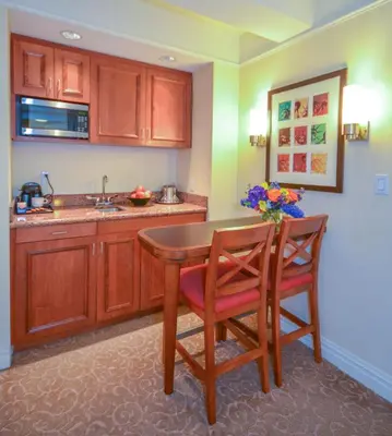 a kitchen with a wooden table and two chairs at San Carlos Hotel New York in New York