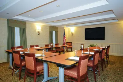 a conference room with tables and chairs and a flat screen tv at San Carlos Hotel New York in New York