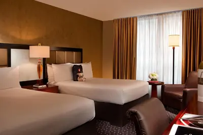 a hotel room with two beds and a chair at Millennium Hotel Broadway Times Square in New York