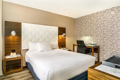 a hotel room with a large bed and a desk at The Gallivant Times Square in New York