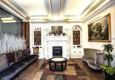 a living room with a fireplace and a couch and a table at Night Hotel Broadway in New York