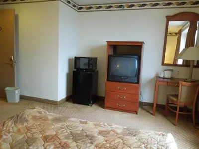 a room with a bed and a television and a table at Red Carpet Inn Brooklyn in Brooklyn
