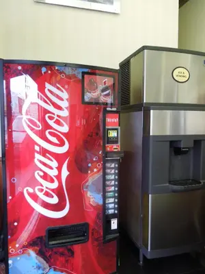 a coca cola vending machine next to a popcorn machine at Red Carpet Inn Brooklyn in Brooklyn