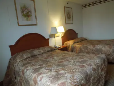 a hotel room with two beds and two lamps at Red Carpet Inn Brooklyn in Brooklyn