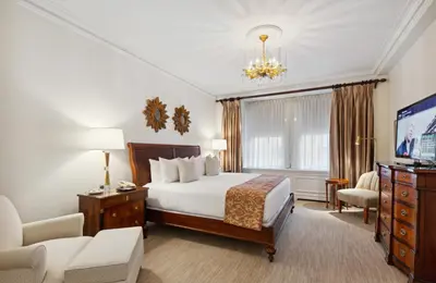 a hotel room with a bed and a tv at The Sherry Netherland in New York