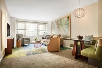 a living room with a couch and a table at The Gardens Sonesta ES Suites New York in New York