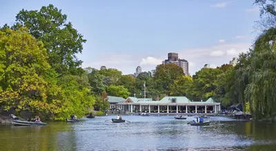 people in boats on a river in front of a building at The Gardens Sonesta ES Suites New York in New York