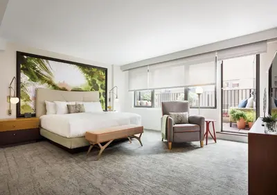 a bedroom with a large bed and a chair at The Gardens Sonesta ES Suites New York in New York