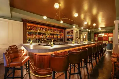 a bar with a row of bar stools at The Benjamin Royal Sonesta New York in New York