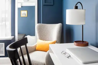 a desk with a chair and a table with a laptop at voco The Franklin New York by IHG in New York