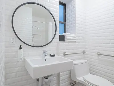 a white bathroom with a sink and a mirror at voco The Franklin New York by IHG in New York