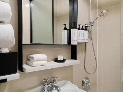 a bathroom with a shower and a sink and a mirror at voco The Franklin New York by IHG in New York