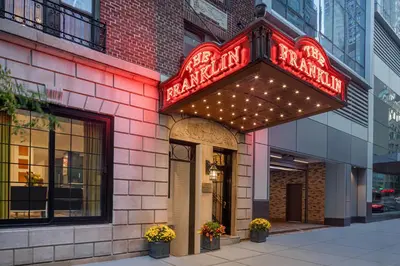 a restaurant with a neon sign on the side of a building at voco The Franklin New York by IHG in New York