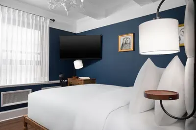 a bedroom with a white bed and a tv at voco The Franklin New York by IHG in New York