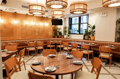 a restaurant with tables and chairs and lights at The Shelburne Sonesta New York in New York