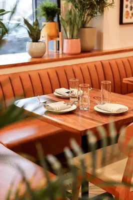 a wooden table with plates and glasses on it at The Shelburne Sonesta New York in New York