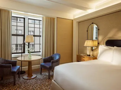 a hotel room with a bed and a table and chairs at The Surrey, A Corinthia Hotel in New York