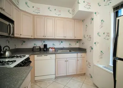 a kitchen with white cabinets with butterflies on the wall at Murray Hill East Suites - Extended Stay in New York