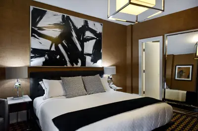a bedroom with a large bed and a painting on the wall at Ameritania at Times Square in New York