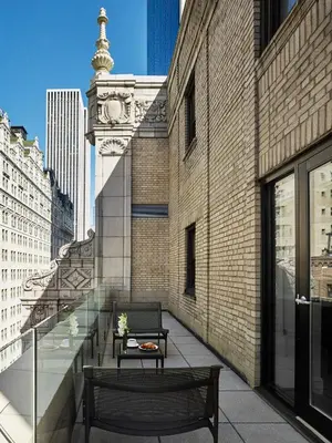 a balcony with a bench and a clock tower on a building at AKA Central Park in New York