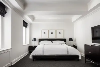 a white bedroom with a bed and a tv at AKA Sutton Place in New York