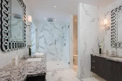 a white bathroom with a shower and a sink at AKA Sutton Place in New York
