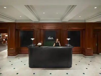 a woman sitting at a counter in a lobby at AKA Sutton Place in New York