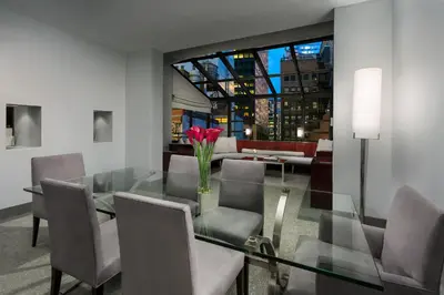 a dining room with a glass table and chairs at Royalton New York in New York