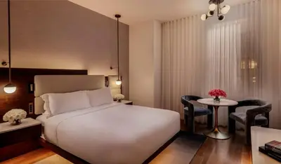 a bedroom with a bed and a table and chairs at Bryant Park Hotel in New York