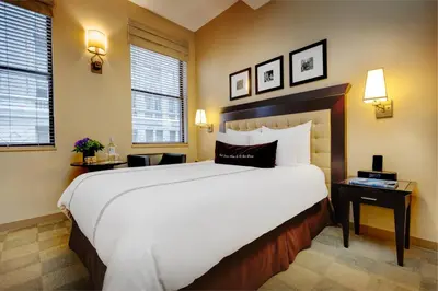 a hotel room with a large bed and two windows at Library Hotel by Library Hotel Collection in New York