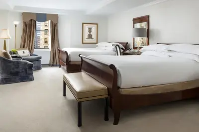 a hotel room with two beds and a chair at The Michelangelo New York in New York