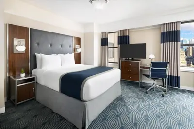 a hotel room with a bed and a desk at New Yorker by Lotte Hotels in New York