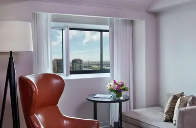 a living room with a chair and a window at Millennium Hilton New York One UN Plaza in New York