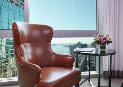 a brown leather chair sitting in front of a window at Millennium Hilton New York One UN Plaza in New York