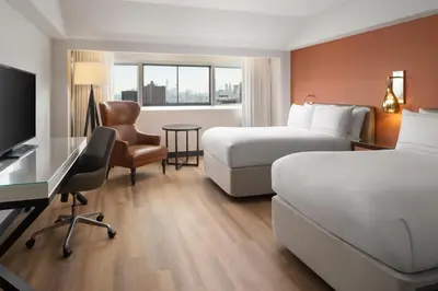 a hotel room with two beds and a desk at Millennium Hilton New York One UN Plaza in New York